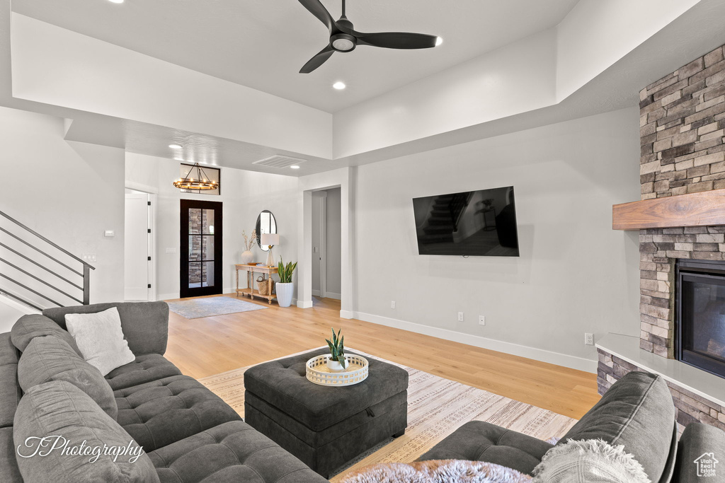 Living area with stairway, wood finished floors, baseboards, recessed lighting, and a fireplace