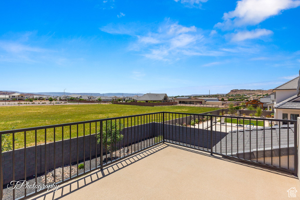 View of patio with a balcony, a mountain view, and a residential view