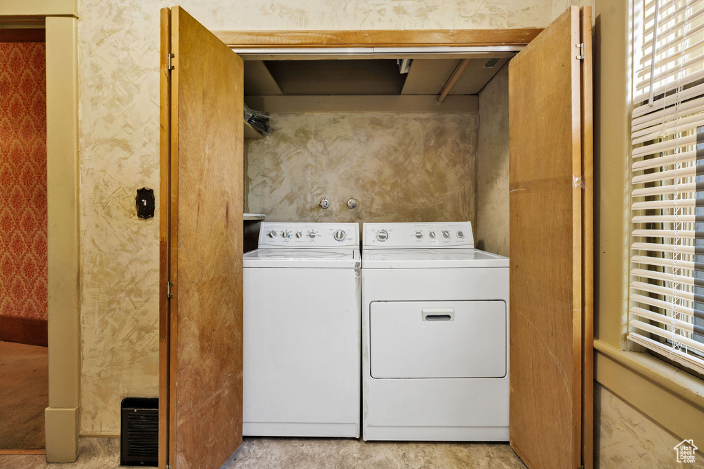 Laundry area with washing machine and dryer, plenty of natural light, and wallpapered walls