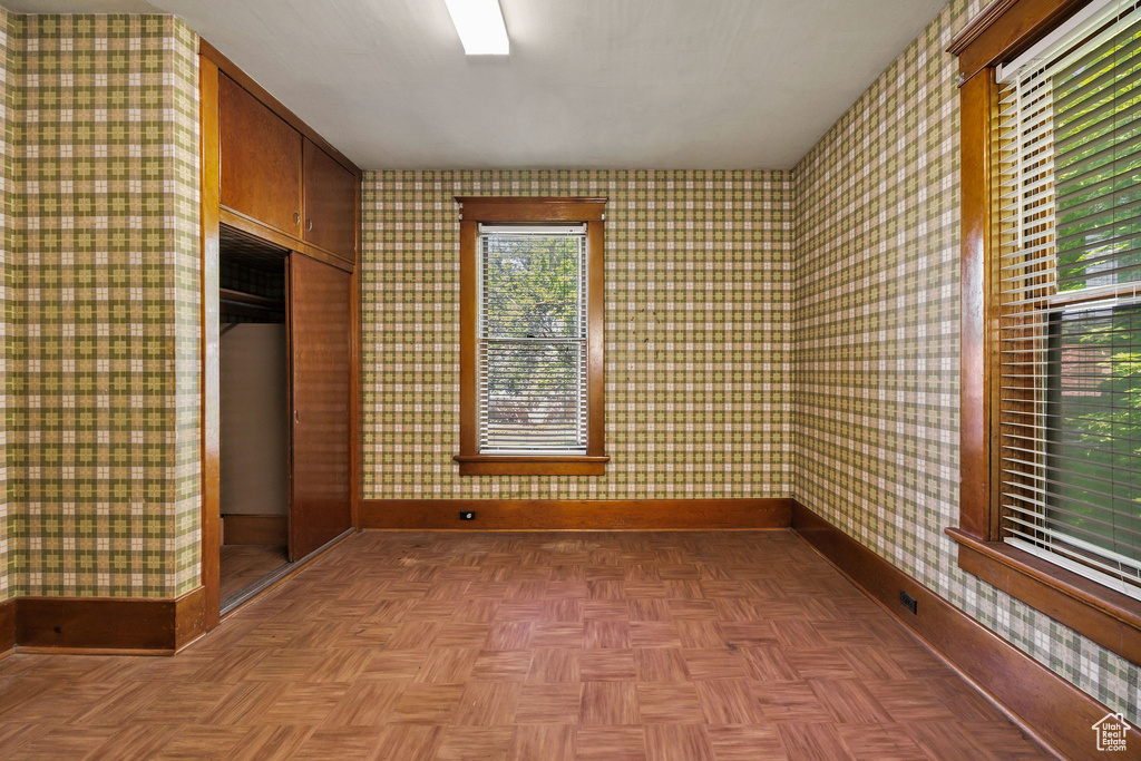 Spare room with baseboards and wallpapered walls
