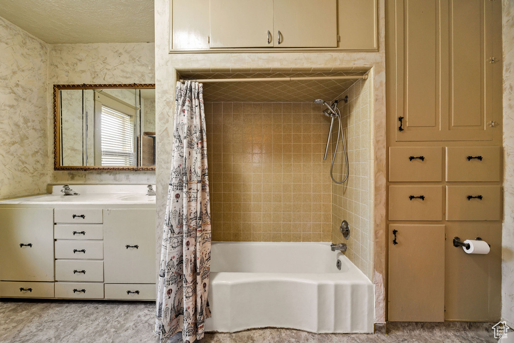 Bathroom featuring shower / bath combination with curtain and double vanity