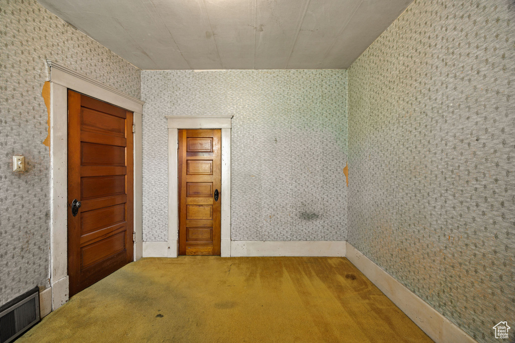 Unfurnished room featuring wallpapered walls and carpet flooring