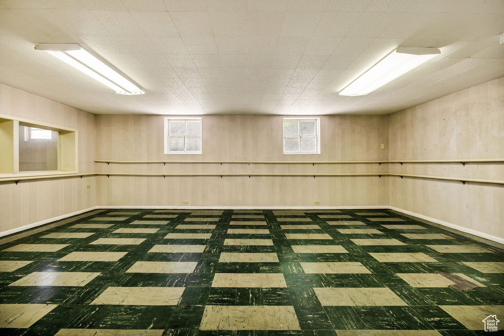 Below grade area with tile patterned floors and wooden walls