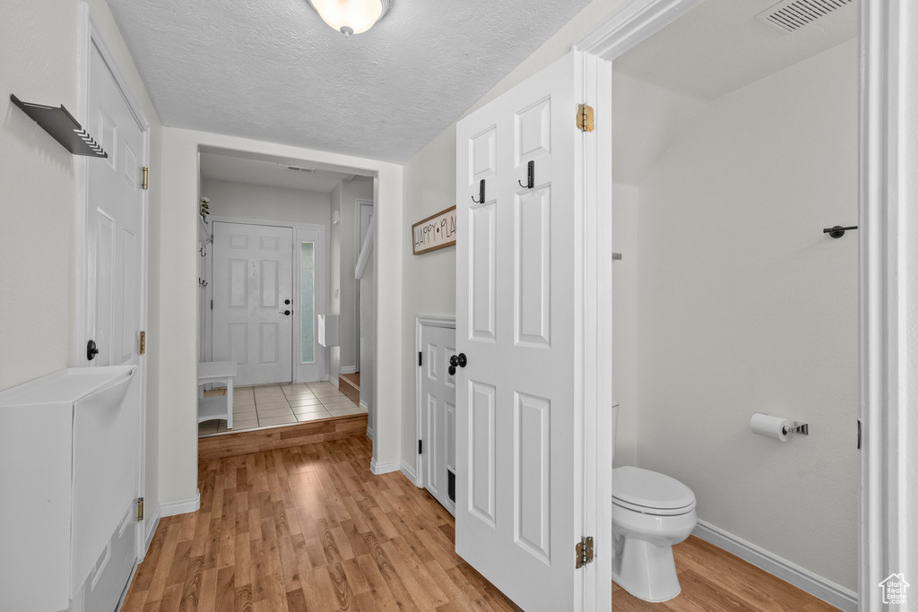 Hall with light wood finished floors and baseboards