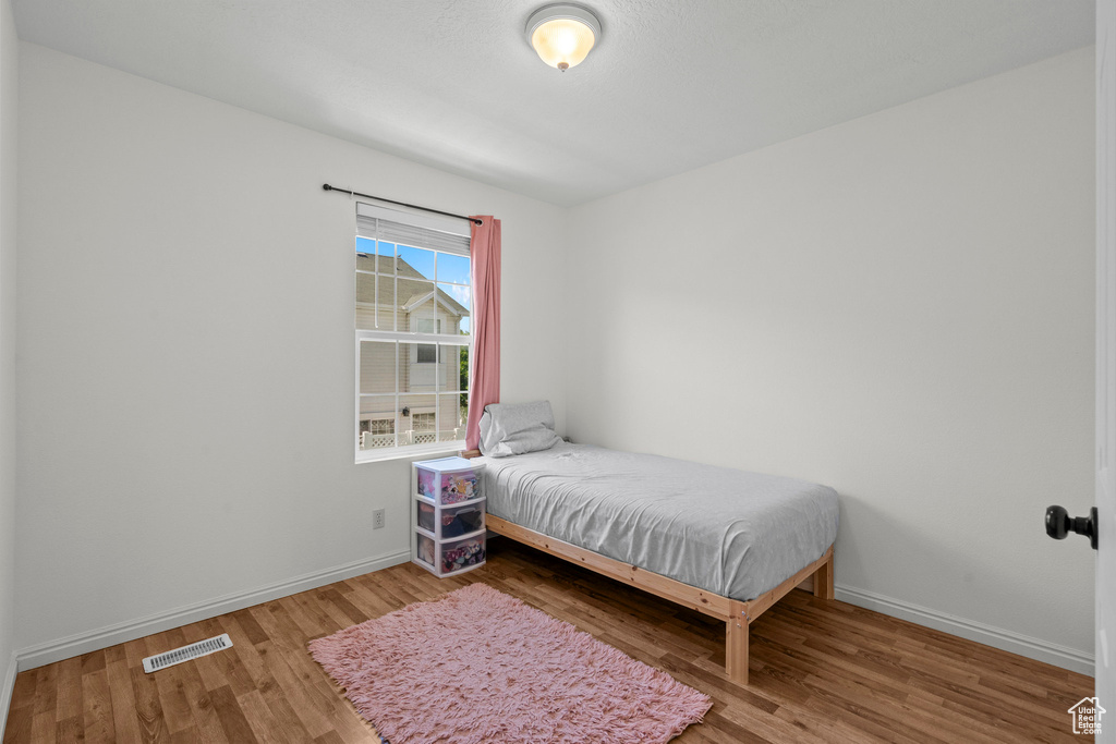 Bedroom with wood finished floors and baseboards
