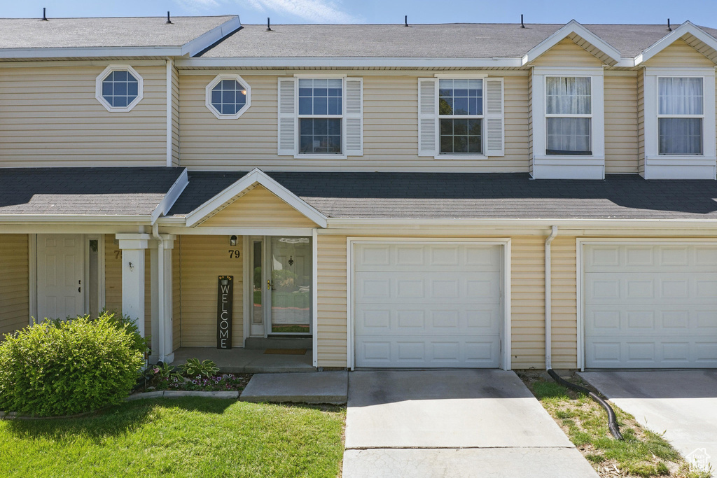 Townhome / multi-family property featuring driveway, covered porch, roof with shingles, and a garage