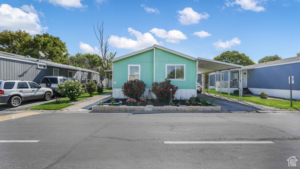 Manufactured / mobile home featuring an attached carport and driveway