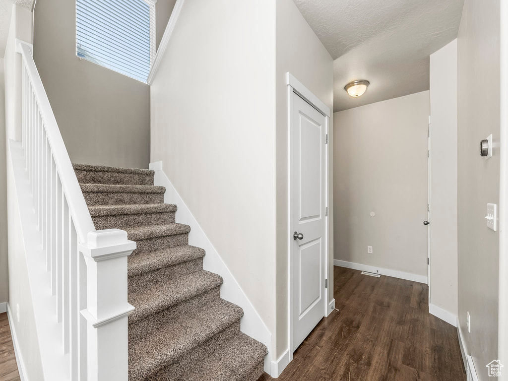 Stairs featuring wood finished floors and baseboards