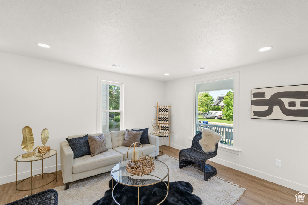 Living area with light wood-style flooring, baseboards, and recessed lighting