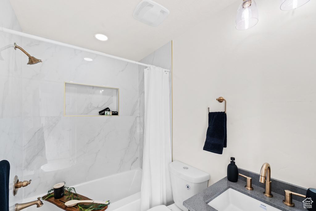 Bathroom featuring toilet, shower / tub combo with curtain, and vanity