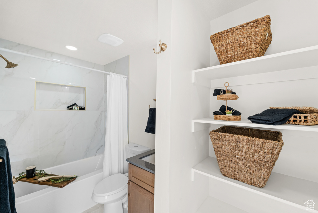 Bathroom featuring shower / tub combo, toilet, and vanity