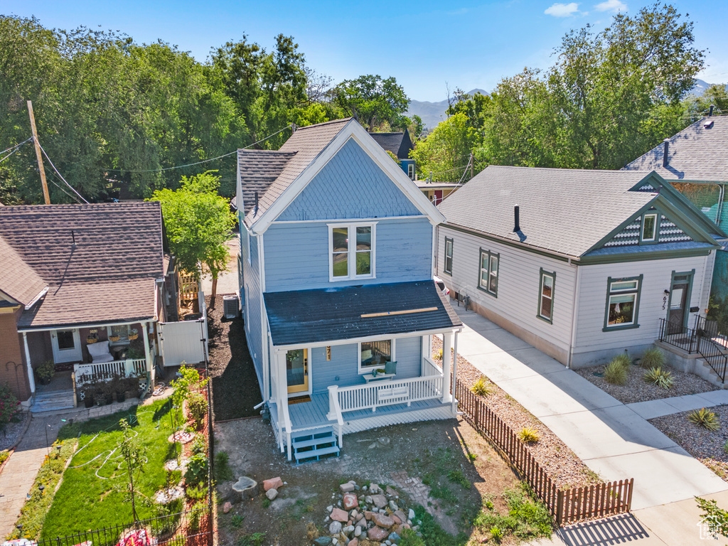 Back of house featuring a shingled roof and a porch