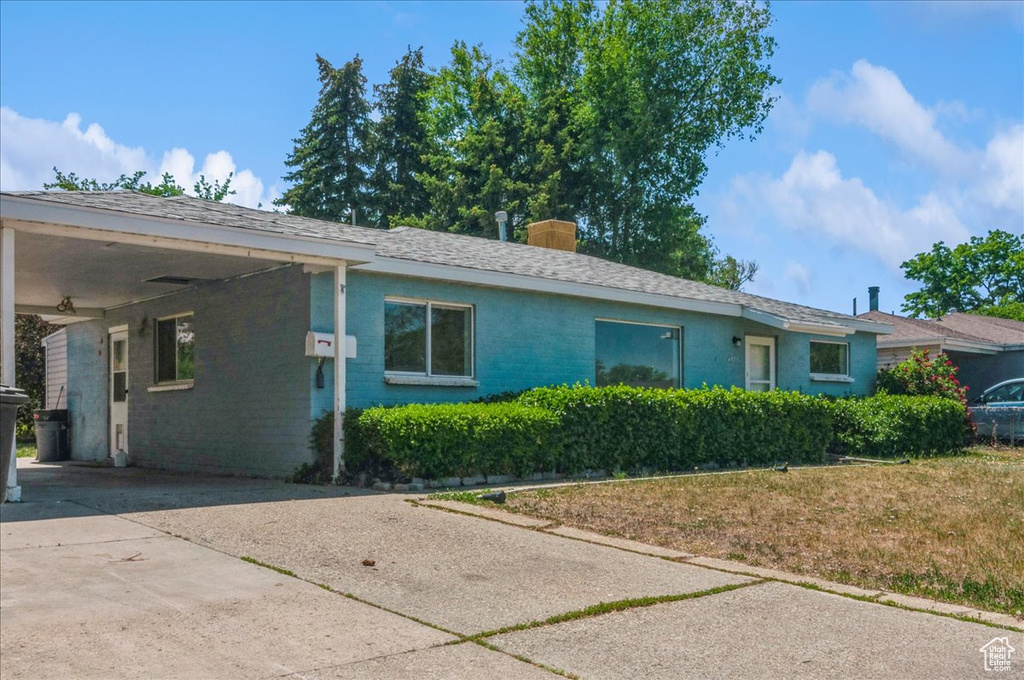 View of front of property with a carport, concrete driveway, and brick siding