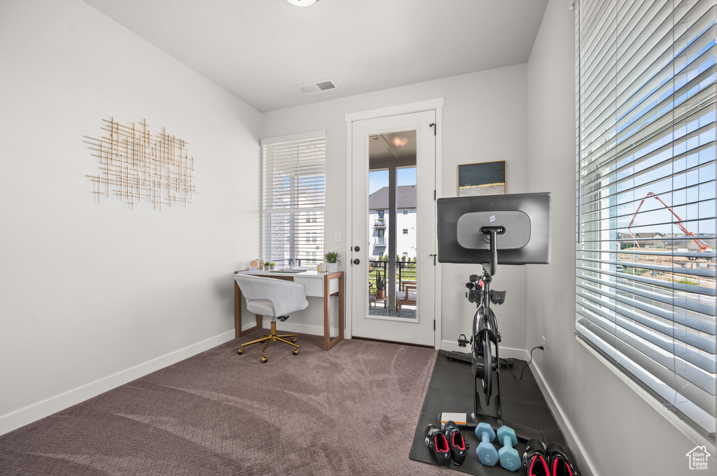 Exercise room with carpet flooring and baseboards