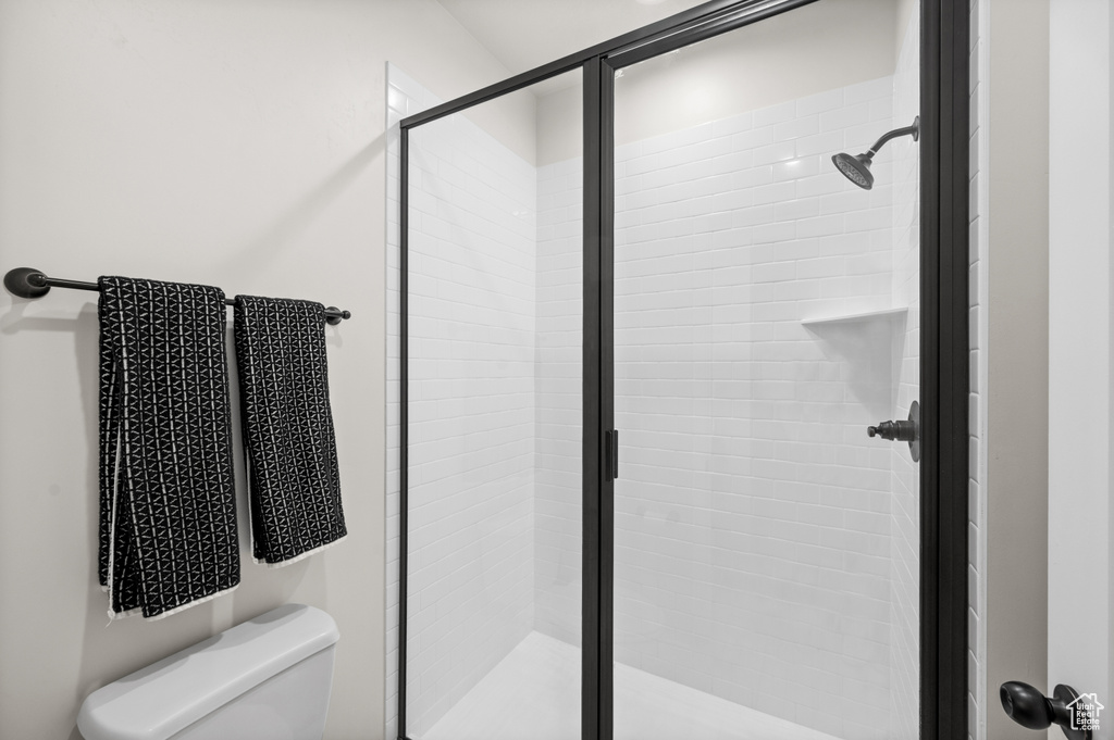 Bathroom featuring a shower stall and toilet