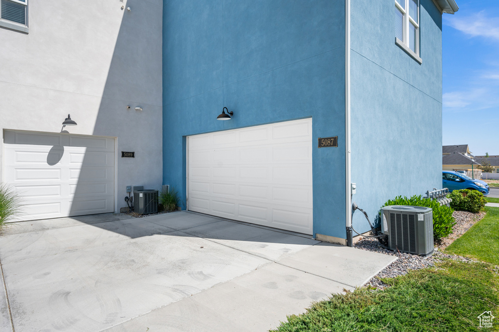 Garage featuring central AC and concrete driveway