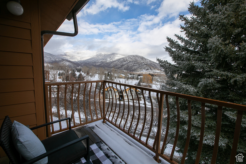 Snow covered back of property with a mountain view