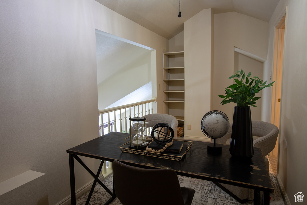 Office space with vaulted ceiling and baseboards
