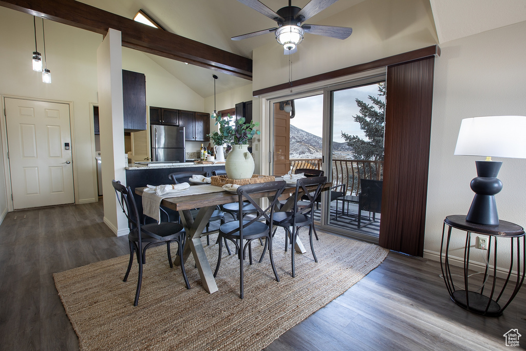 Dining space with dark wood-style flooring, baseboards, ceiling fan, beamed ceiling, and high vaulted ceiling