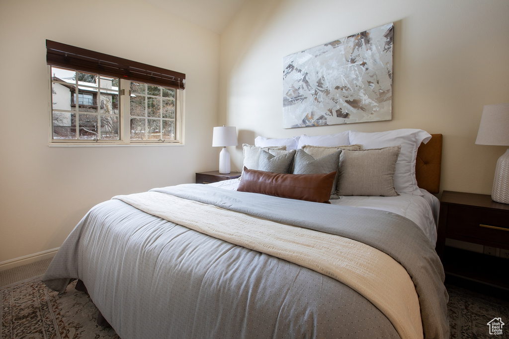 Bedroom with carpet floors and lofted ceiling