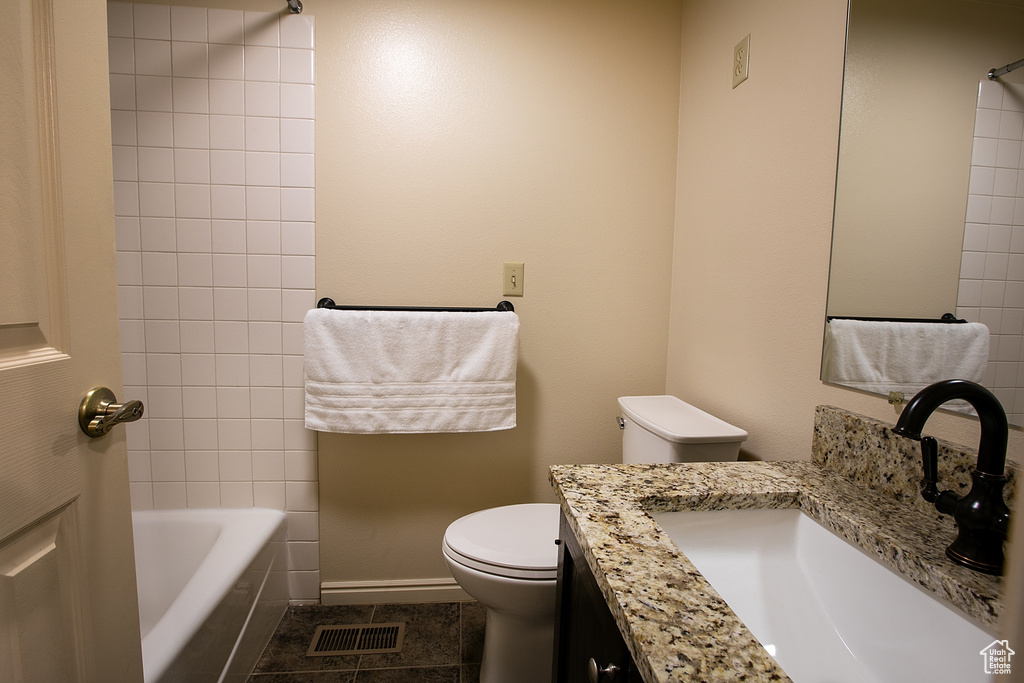 Full bath featuring toilet, vanity, tile patterned flooring, baseboards, and shower / bathtub combination