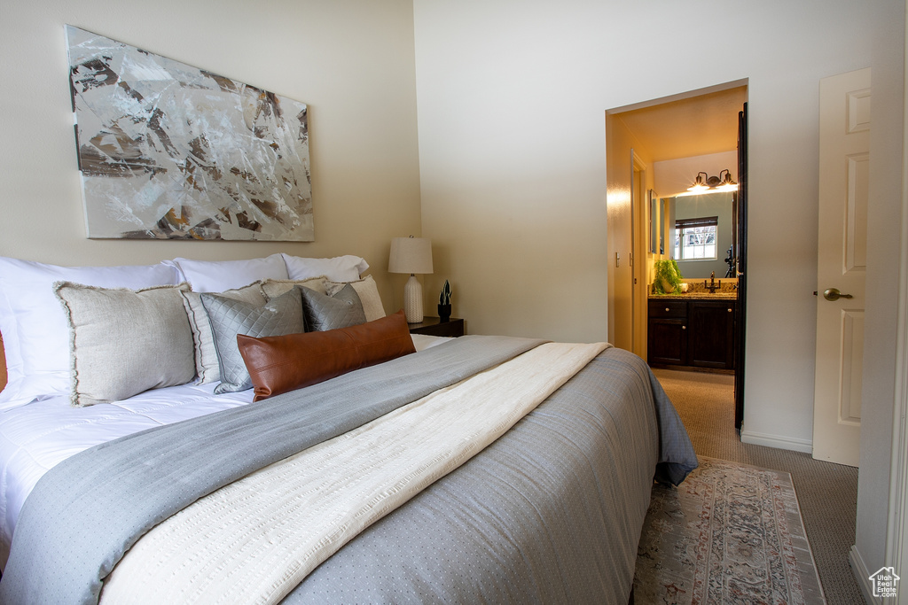 Bedroom with carpet floors, a sink, and ensuite bathroom