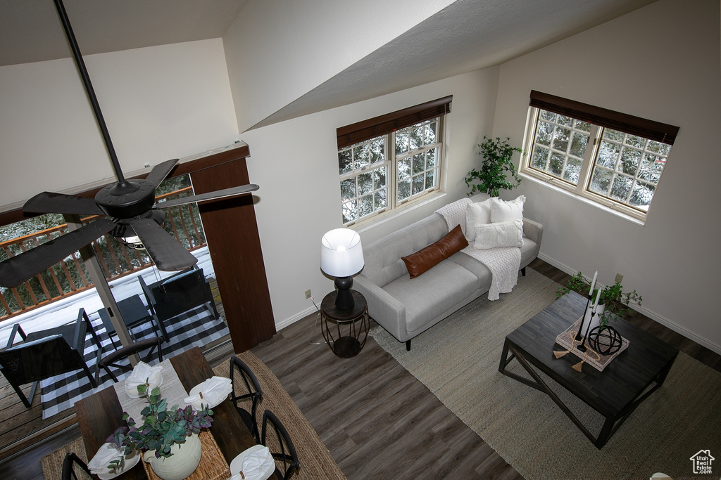 Living room featuring wood finished floors, baseboards, and lofted ceiling