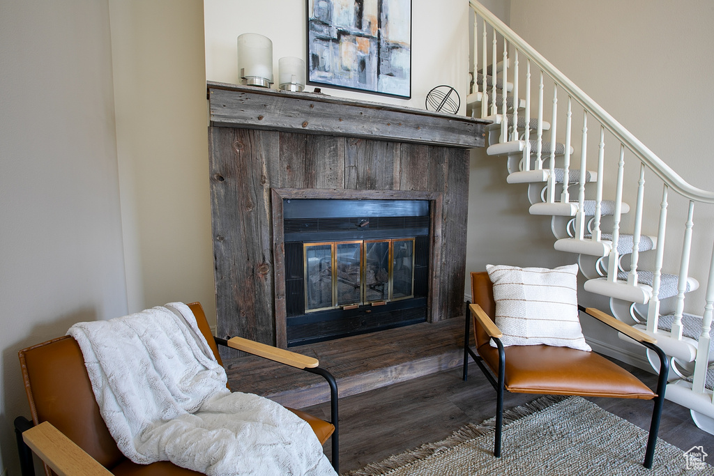Stairway featuring a glass covered fireplace and wood finished floors