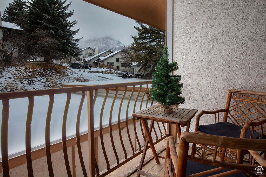 Snow covered back of property with a residential view