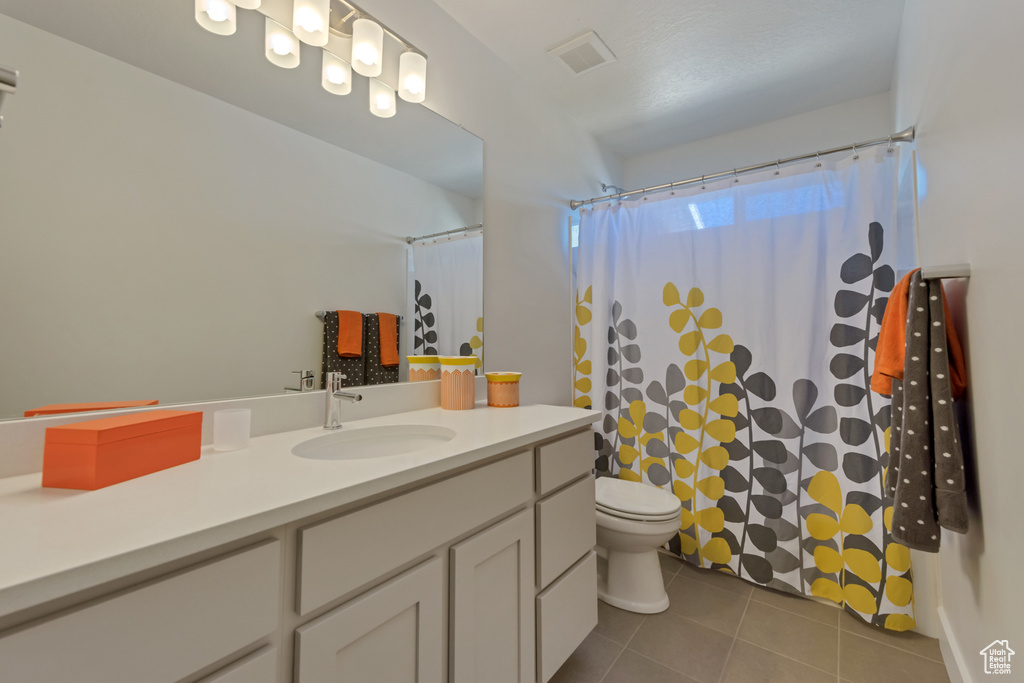 Full bath featuring tile patterned floors, vanity, toilet, and a shower with shower curtain