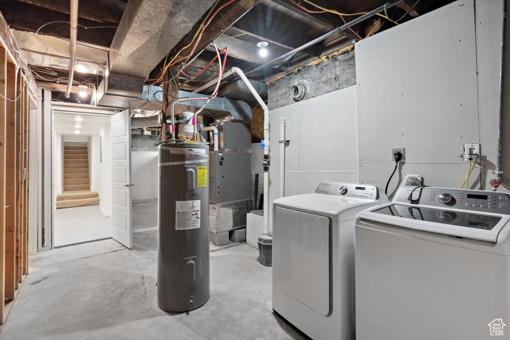 Washroom featuring electric water heater and separate washer and dryer