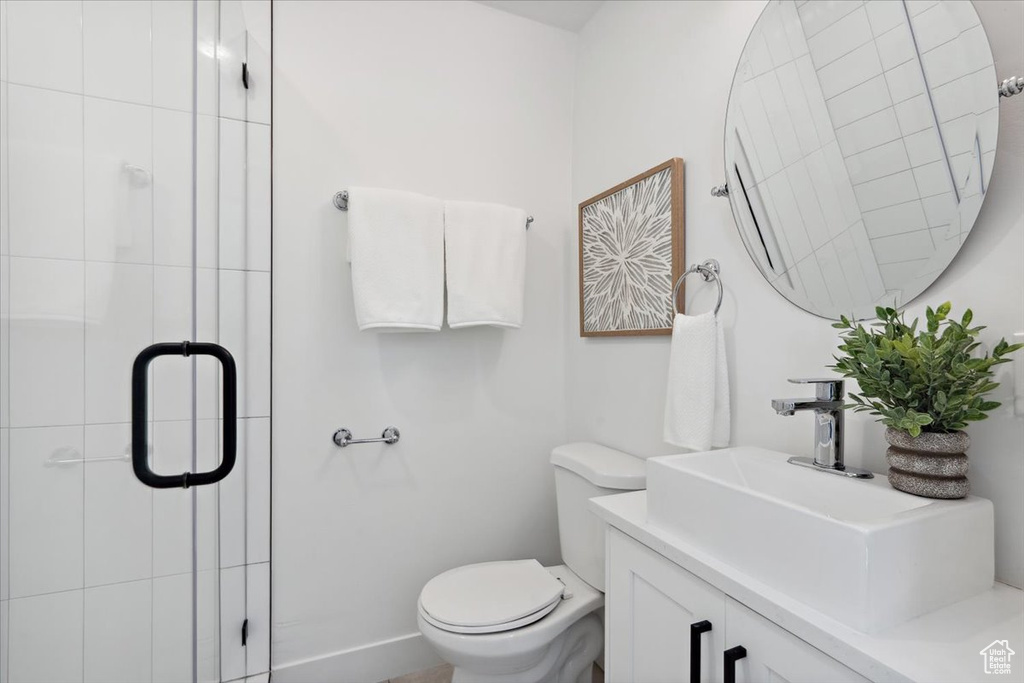 Full bath featuring toilet, vanity, and a stall shower