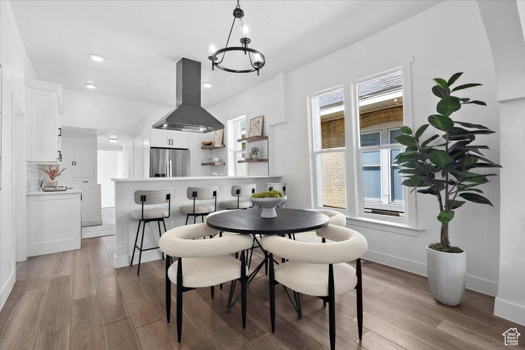 Dining room featuring a chandelier, light wood-style floors, baseboards, and recessed lighting