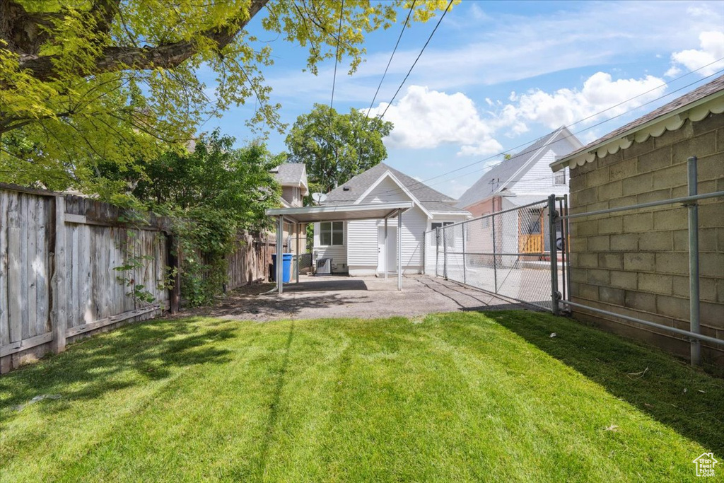 View of yard with a patio area and a gate
