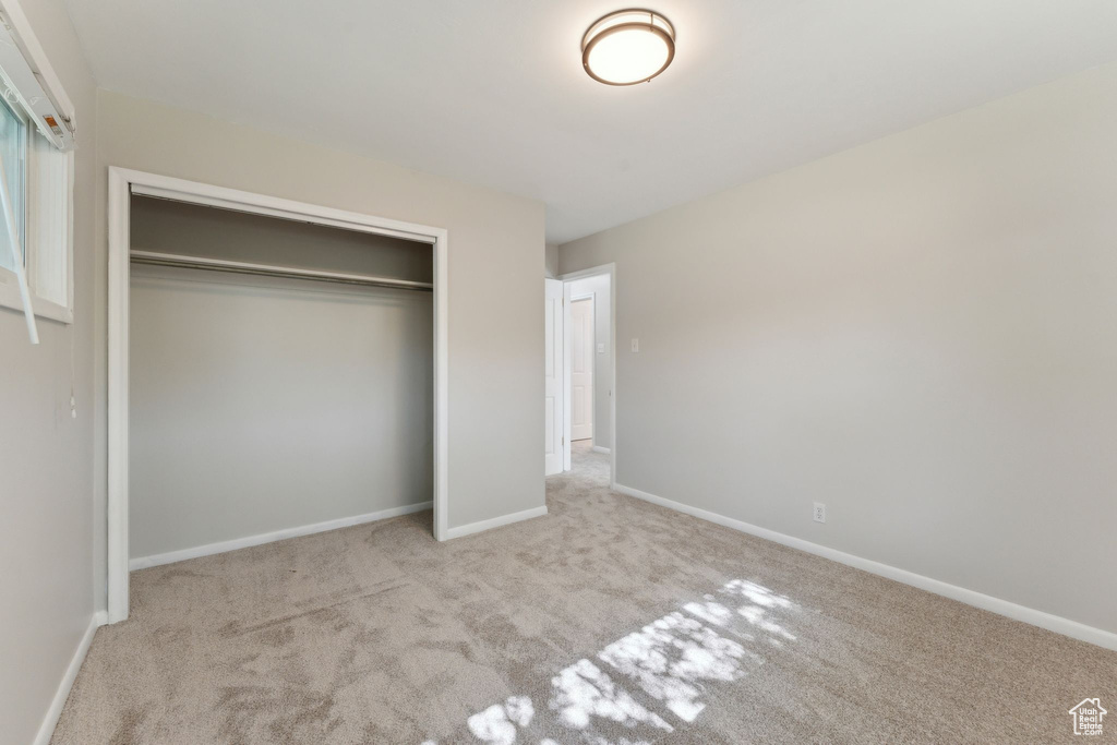 Unfurnished bedroom featuring carpet floors, a closet, and baseboards