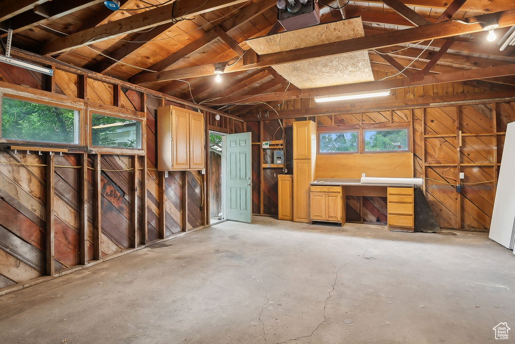 Misc room featuring unfinished concrete floors and wood walls