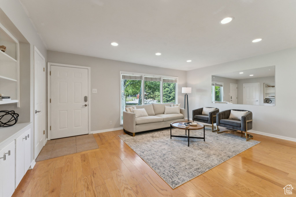 Living room with recessed lighting, light wood-style flooring, and baseboards