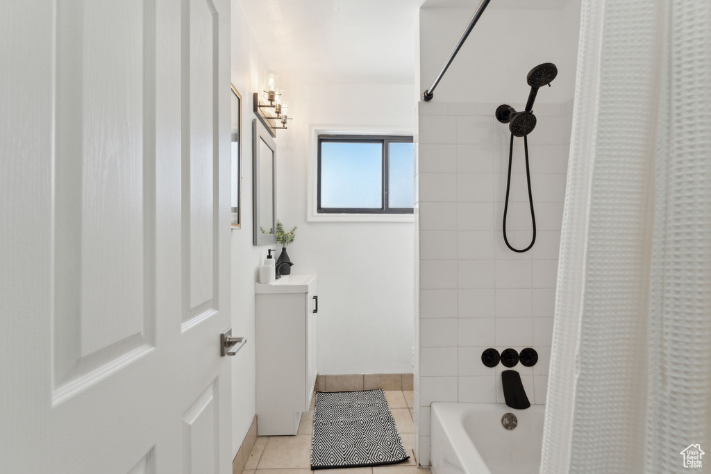 Bathroom featuring vanity, shower / bathtub combination with curtain, and tile patterned floors