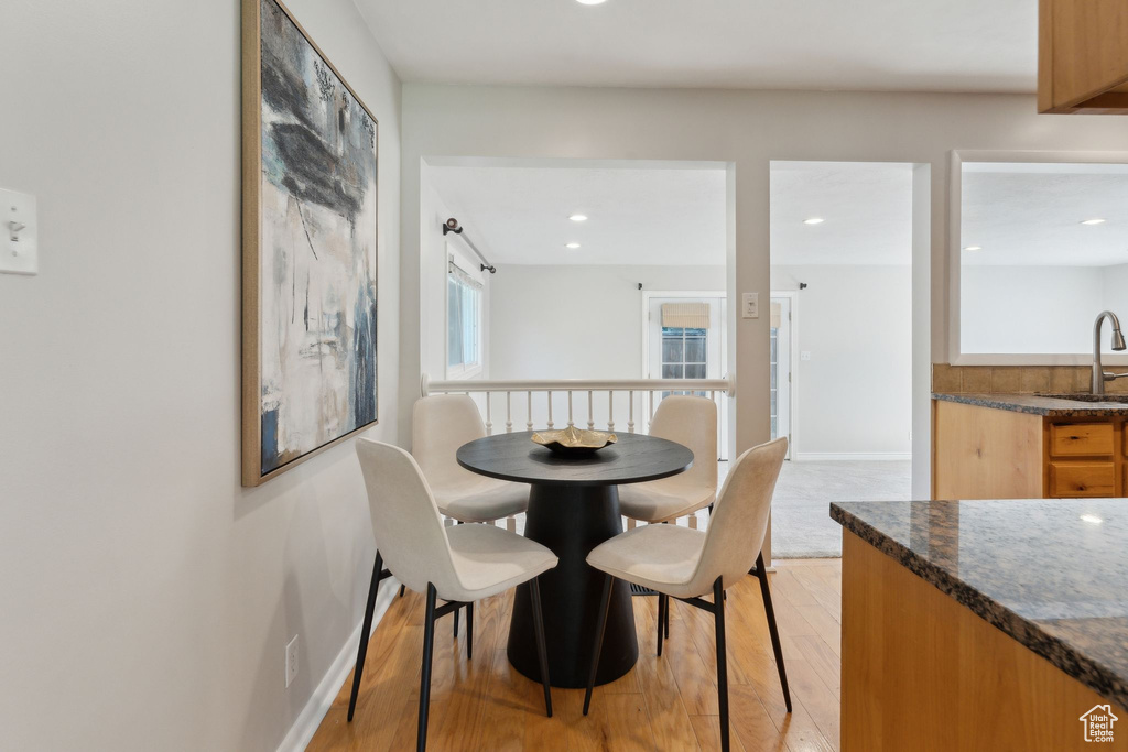 Dining room with light wood-type flooring, baseboards, and recessed lighting