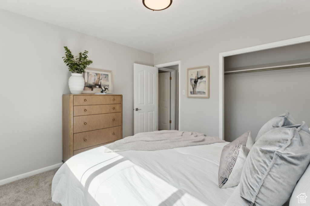 Bedroom featuring light colored carpet, a closet, and baseboards