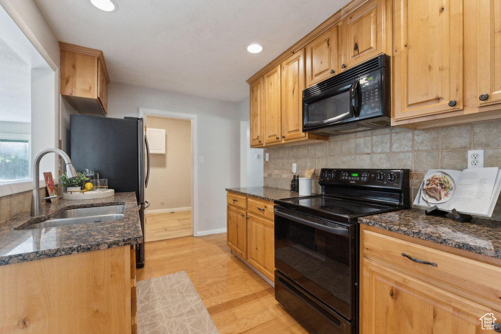 Kitchen with black appliances, a sink, light wood-style flooring, tasteful backsplash, and recessed lighting