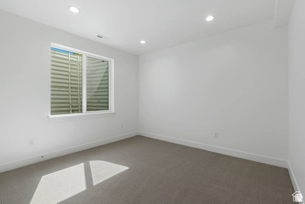 Carpeted empty room with recessed lighting and baseboards