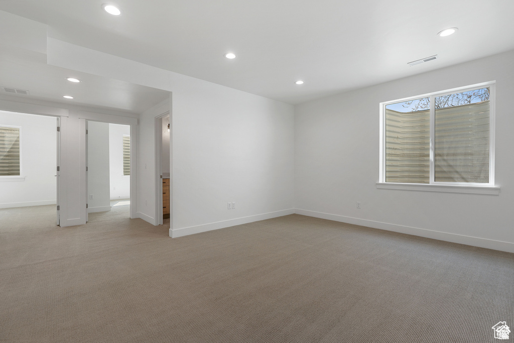 Unfurnished room with recessed lighting, light carpet, and baseboards