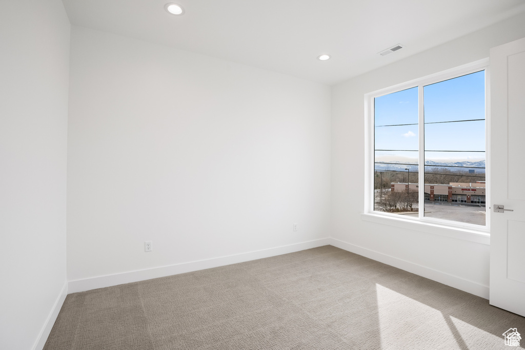 Spare room featuring carpet flooring, baseboards, and recessed lighting