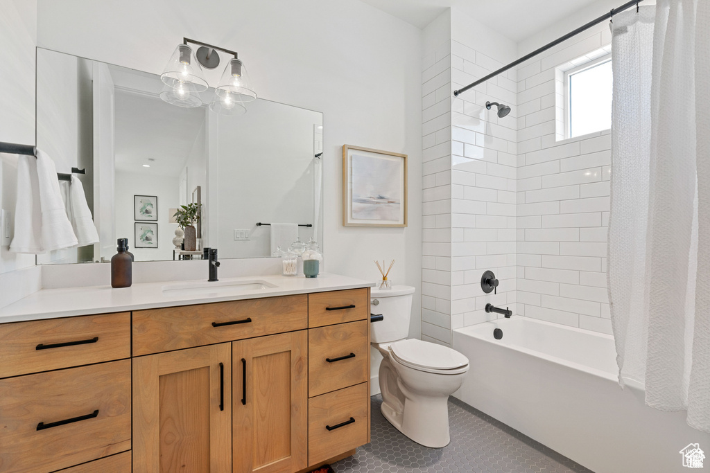 Bathroom featuring vanity, toilet, shower / bath combo with shower curtain, and tile patterned flooring