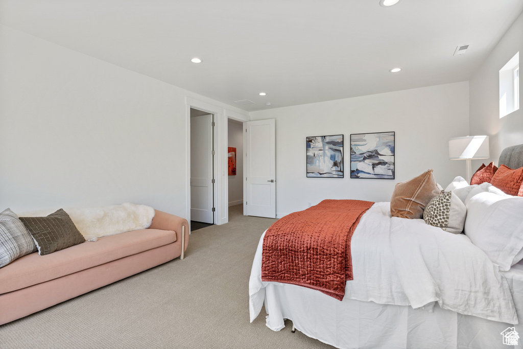 Bedroom with light colored carpet and recessed lighting