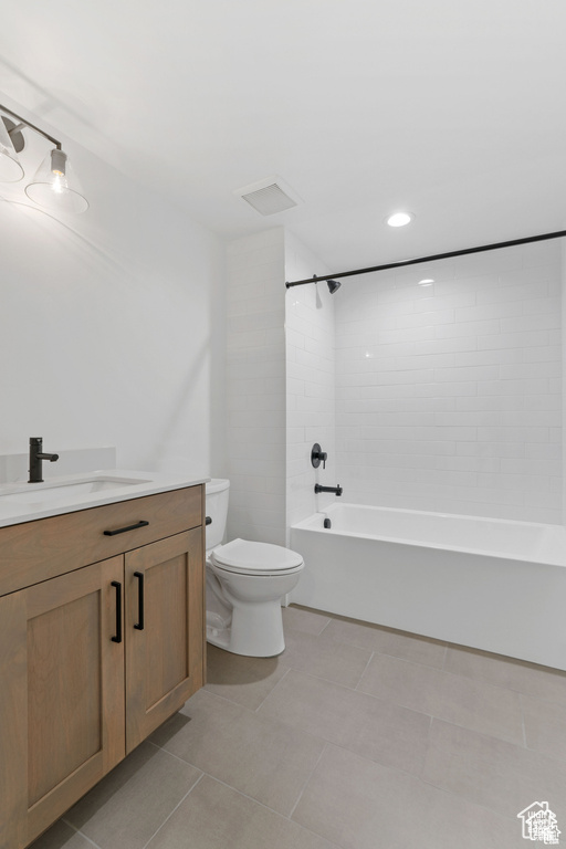 Bathroom with toilet, vanity,  shower combination, and tile patterned flooring