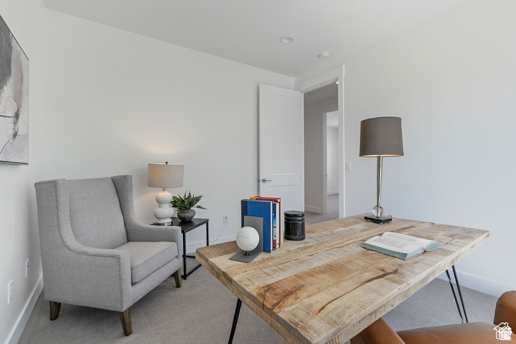 Carpeted home office featuring baseboards