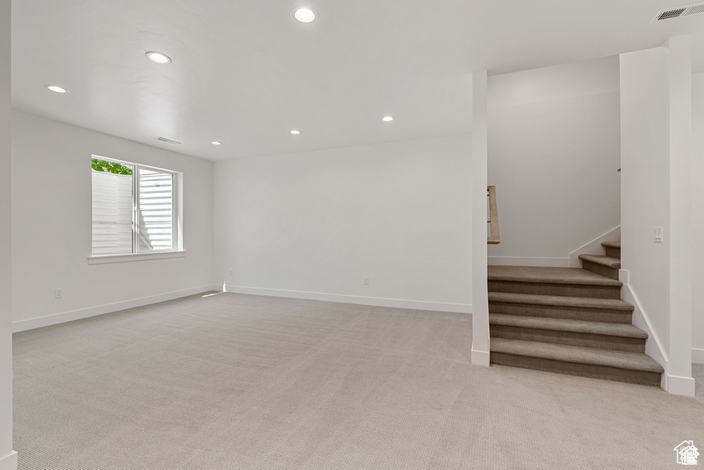 Empty room with light carpet, stairway, recessed lighting, and baseboards