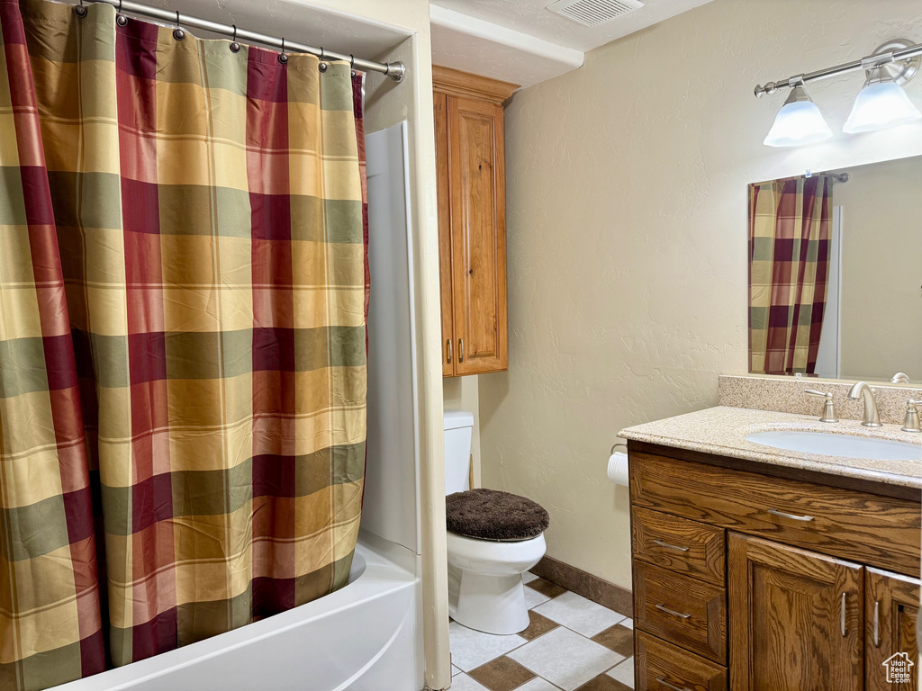 Full bath with toilet, vanity, shower / tub combo, and baseboards